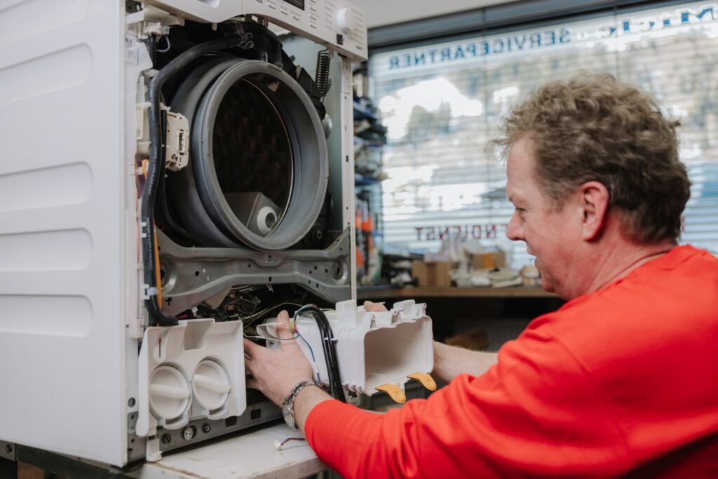 Mitarbeiter repariert eine Waschmaschine
